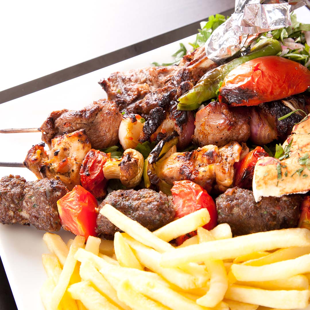Kebabs and french fries on white plate